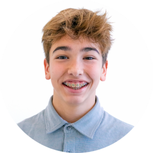 Un adolescent sourit joyeusement, révélant ses dents ornées d'un appareil dentaire.