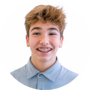 Un adolescent sourit joyeusement, révélant ses dents ornées d'un appareil dentaire.