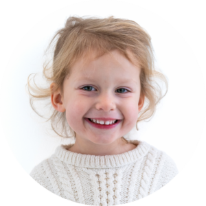 Un enfant aux cheveux blonds qui affichent un sourire éclatant 