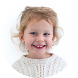Un enfant aux cheveux blonds qui affichent un sourire éclatant 