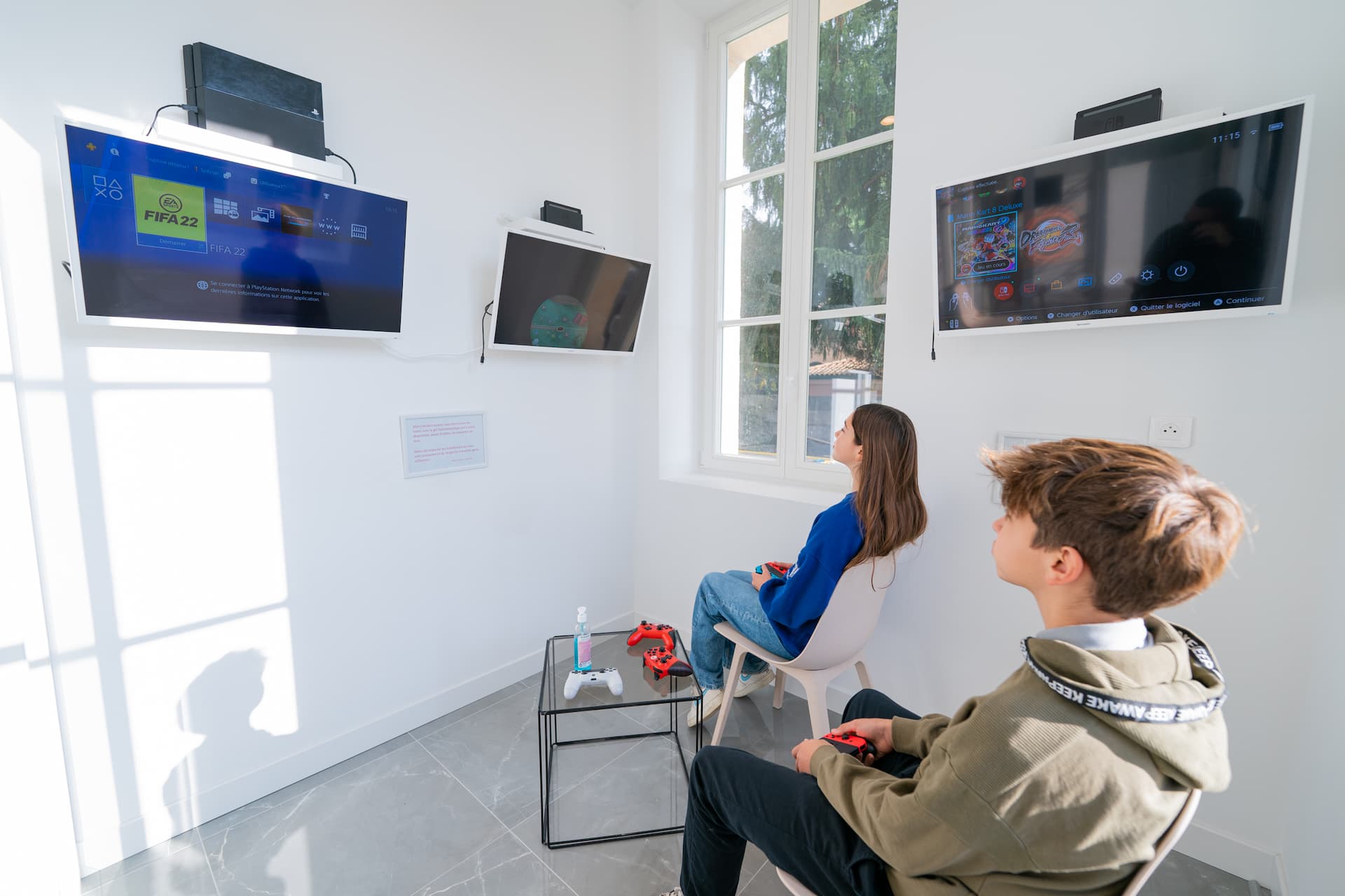Deux jeunes adolescents jouent à des jeux-vidéos dans la salle d'attente