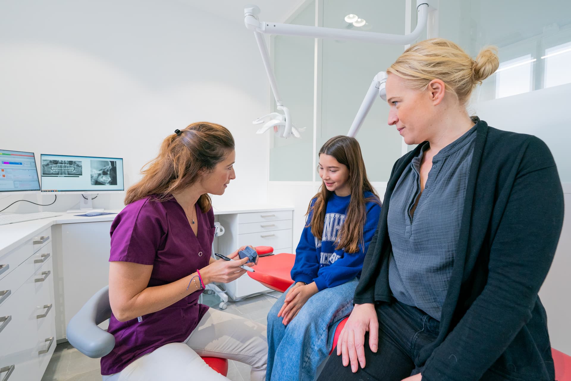 L'orthodontiste Camille Tavera discute avec une mère et sa fille