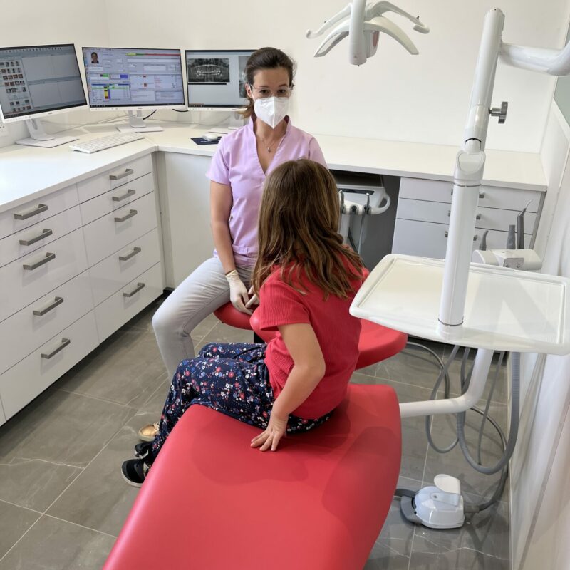 Une orthodontiste discute avec sa jeune patiente